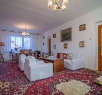 Living room in a family house with a carpet, sofas, and a table sufficient for comfortable relaxation.