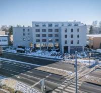 A building in the city of Poprad with a snowy surrounding and an intersection in the foreground.