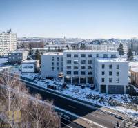 Winter panorama of Poprad with buildings on a snowy street.