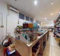 Interior of commercial premises with shelves, drinks, and a cash register, air conditioning in the back.