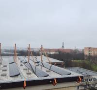 A view of Spartakovská Street in Trnava with buildings and solar panels on the roof.