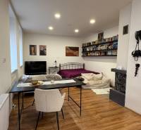 Interior of a 1-room apartment with a wooden floor, a bed, and a dining table.