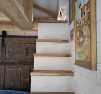 Wooden stairs in a family house, walls with hanging pictures.