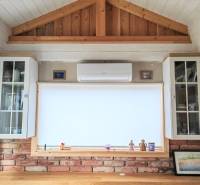 Interior of a family house with air conditioning, a brick wall, and a wooden decor floor.