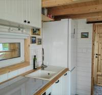 A kitchen in a family house with white furniture and wooden elements.