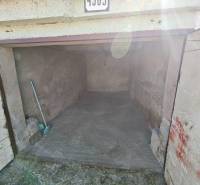 Garages on Okružná Street in Michalovce with concrete flooring and a broom.