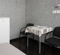 Interior with black and white patterned wallpaper, a standalone refrigerator, a table, and two chairs.