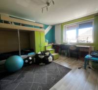 Children's room in a family house with a bunk bed, a desk, and a floor with a wooden decor.