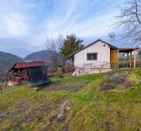 A cottage in Prešov surrounded by trees, with a view of the hills and a trampoline in the garden.