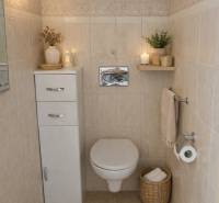A bathroom in a 3-room apartment with storage space, candles, and textile accessories.