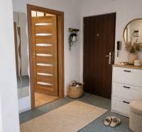 3-room apartment with warm lighting, wooden doors, and white furniture.