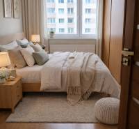 Bedroom with a bed, carpet, and wooden decor flooring in a 3-room apartment.