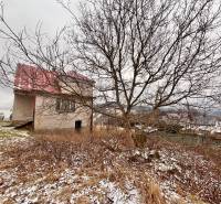 A family house in Poľana in Skalité without foliage, with the surroundings covered in light snow.