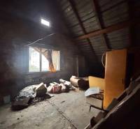 Attic room with a window in a family house full of old items and furniture.