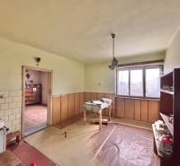 Interior of a family house with furniture, a window, and a floor with a wooden decor.