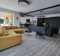 Living room in a family house with a wood-patterned floor and a comfortable sofa.