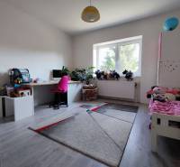 Children's room in a family house with a wooden decor floor, a desk, and toys.