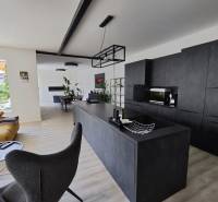 Living room connected with the kitchen in a family house with a wooden decor floor.
