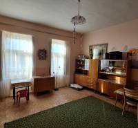 Living room of a family house with wooden furniture, carpet, and table.