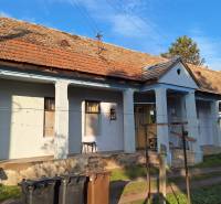 A family house in Rapovce with traditional architecture, a veranda, and a shingle roof.