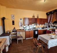 A kitchen with wooden decor, rustic cabinets, and decorations in a family house.