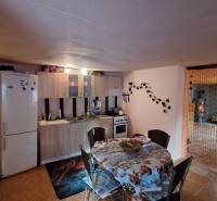 A kitchen in a family house with a dining table, kitchen counter, and refrigerator.