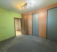 A room in a three-room apartment with a colored wall, a wardrobe, and bright lighting.