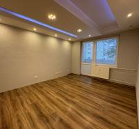 A room in a 3-room apartment with a wooden decor floor and spot lighting.