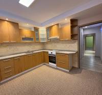 A kitchen in a 3-room apartment with wooden decor and built-in appliances.