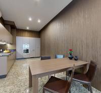 A kitchen in a 3-room apartment with a dining table, built-in appliances, and stylish chairs.