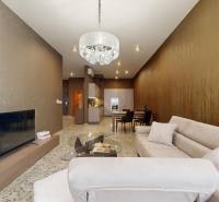 Living room in a 3-room apartment with a comfortable sofa, chandelier, and television.