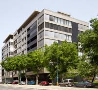 Apartment building on Námestie Slobody in Bratislava - Staré Mesto surrounded by trees and parked cars.