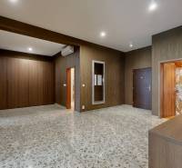 A wide hallway in a 3-room apartment with dark panels and a stone floor.