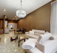 Living room with a beige sofa and an open kitchen in a 3-room apartment.