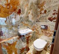 A bathroom with a striking stone cladding in a 3-room apartment.