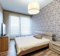 A bedroom in a 3-room apartment with decorative wallpaper and a wooden decor floor.