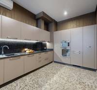 A kitchen with built-in appliances and a wooden decor floor in a 3-room apartment.