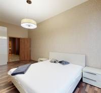 Bedroom in a 3-room apartment with a bed, wardrobe, and floor with wood decor.