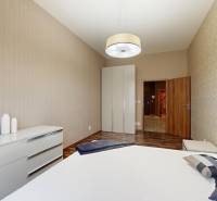 A bedroom in a 3-room apartment with a wooden decor floor and a built-in wardrobe.