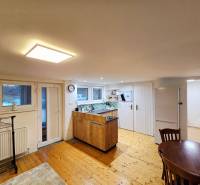 A kitchen in a studio apartment with a wooden decor floor and a table.