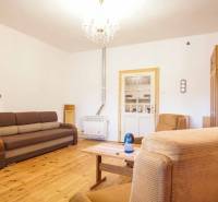 Living room in a family house with a wooden decor floor, sofa, and armchairs.