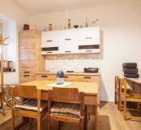 A dining room with wooden furniture and a floor with a wooden design in a family house.