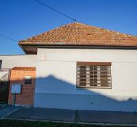 A family house in Nové Zámky on Pod kopcom Street with a brick roof and a metal gate.
