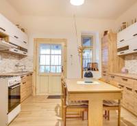 A kitchen in a family house with a wood-patterned floor and white cabinets.