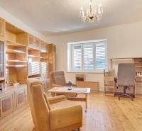 Living room with wooden furniture, wood-patterned floor, chandelier.