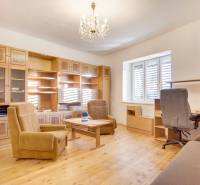 Interior of a family house with furniture, wood-patterned flooring, and a chandelier.