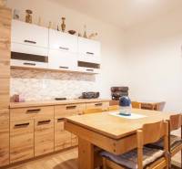 A kitchen in a family house with wooden furniture and a floor with a wooden decor.