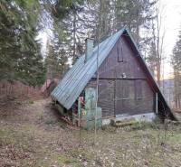 A cottage in the forest on Krpáčovo street in Krpáčovo with a sloped metal roof.