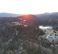 Sunset in Krpáčovo over the forests, lake, and buildings on Krpáčovo street.