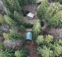 Aerial view of a cabin in the wooded area of Krpáčovo surrounded by dense trees.